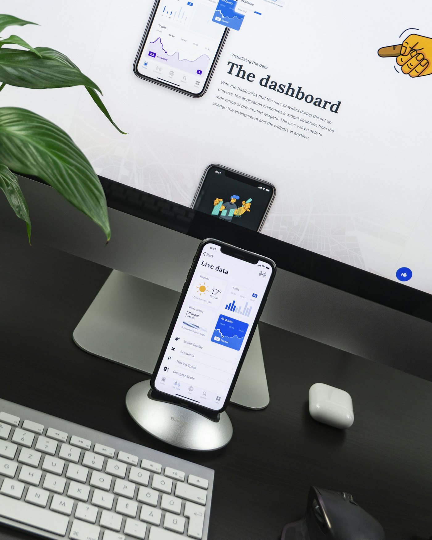 A phone on a stand in front of a monitor, both showing the same app